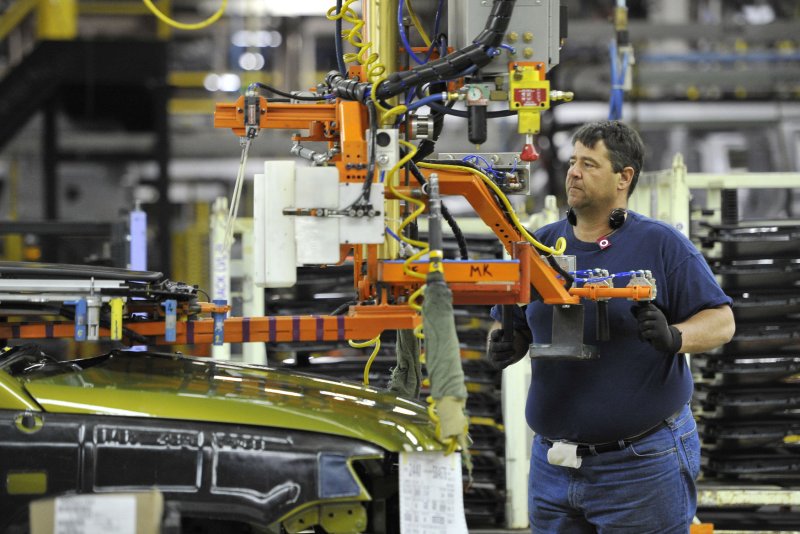 An auto factory worker installs equipment on a vehicle at Chrysler's Belvidere, Ill., assembly plant. File Photo by Brian Kersey/UPI | <a href="/News_Photos/lp/4ee3de4a2071c8aabb3489ace059439b/" target="_blank">License Photo</a>