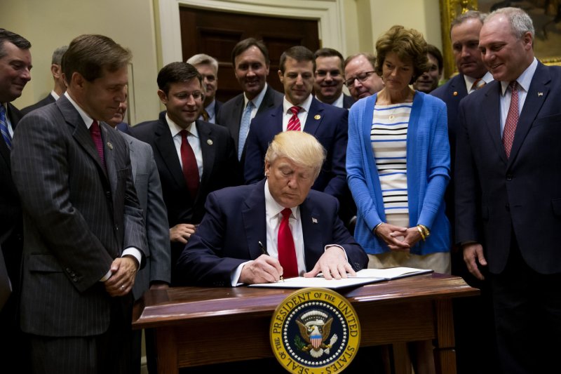 President Donald Trump signs an executive order in the Roosevelt Room of the White House Friday. The order calls for a review that may ultimately expand oil and gas drilling off U.S. coastlines. Photo by Eric Thayer/UPI