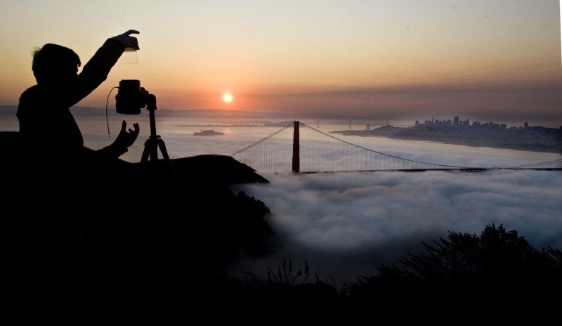 A photographer takes pictures of the sunrise from the Marin Headlands as fog hangs low over San Francisco Bay, in Marin County, California on September 27, 2009. UPI/Terry Schmitt