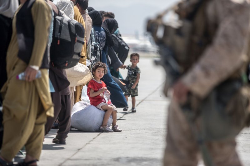 A child waits with her family to board a U.S. Air Force Boeing C-17 Globemaster III on Sunday during an evacuation at Hamid Karzai International Airport in Kabul, Afghanistan. Photo by Sgt. Samuel Ruiz/USMC/UPI