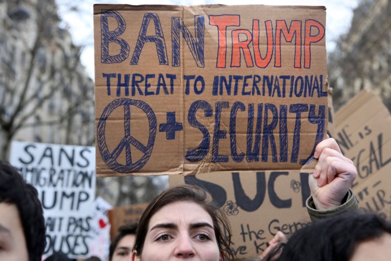 Demonstrators hold placards and shout slogans as they march through the streets of Paris by the Eiffel Tower on Saturday against U.S. President Donald Trump. Photo by Maya Vidon-White/UPI