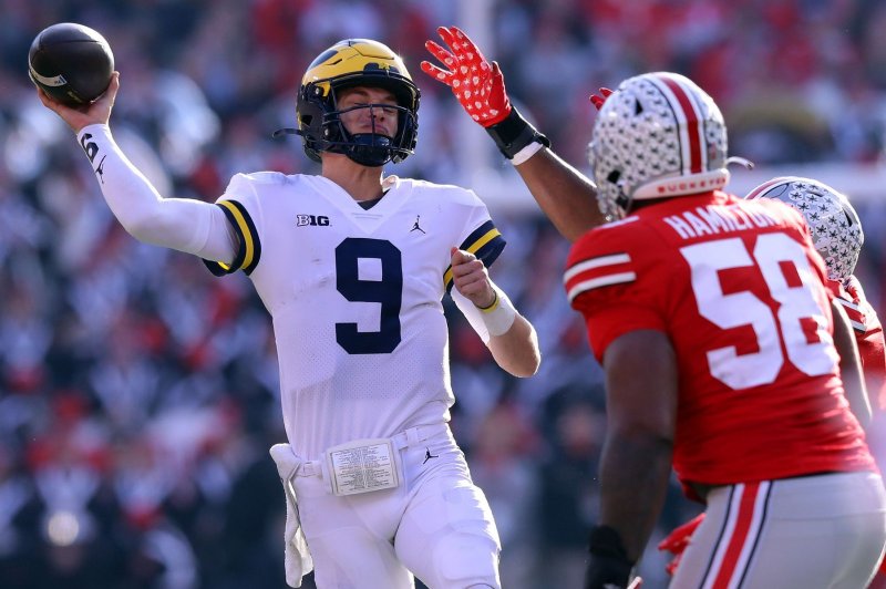 Michigan Wolverines quarterback J.J. McCarthy (9) throws while under pressure from Ohio State Buckeyes defenders Saturday in Columbus, Ohio. Photo by Aaron Josefczyk/UPI