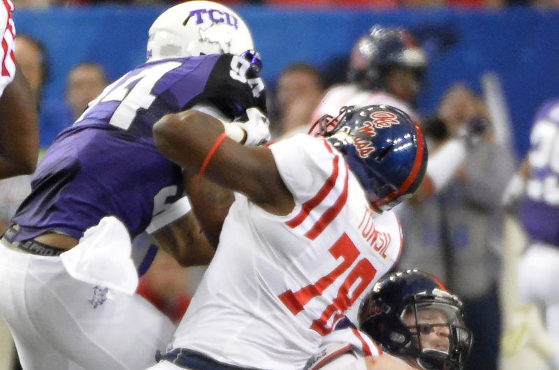 Mississippi offensive lineman Laremy Tunsil (78) severely injures his leg when quarterback Bo Wallace (14) is sacked on top of him by TCU's Josh Carraway (94) during the first half of their Chick-fil-A Peach Bowl game at the Georgia Dome on December 31, 2014, in Atlanta. UPI/David Tulis