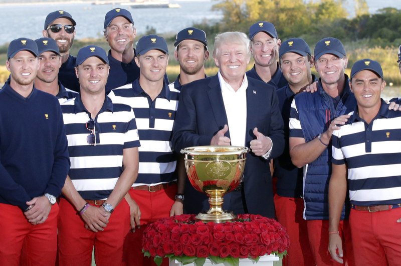 The players of the United States team take a team photo with United States President Donald Trump and the trophy after defeating the International team 19 to 11 total points at the Presidents Cup on October 1, 2017 at Liberty National Golf Club in Jersey City, New Jersey. Photo by John Angelillo/UPI | <a href="/News_Photos/lp/e646c634e50202937d25fed46a433bdb/" target="_blank">License Photo</a>