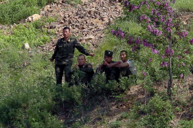 North Korean soldiers sit in the shade near the North Korean city Sinuiju, across the Yalu River from Dandong, China. Soldiers at the border appeared to be "undernourished," according to a Japanese journalist who recently visited the area. Photo by Stephen Shaver/UPI | <a href="/News_Photos/lp/da674290876f18ef8f718a8cc365057a/" target="_blank">License Photo</a>