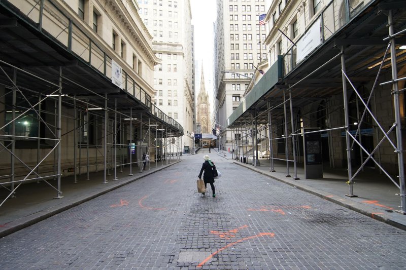 A woman walks on an empty Wall Street in New York City on Monday. New York Gov. Andrew Cuomo said Tuesday governments must not rush to reopen and risk greater loss of life. Photo by John Angelillo/UPI