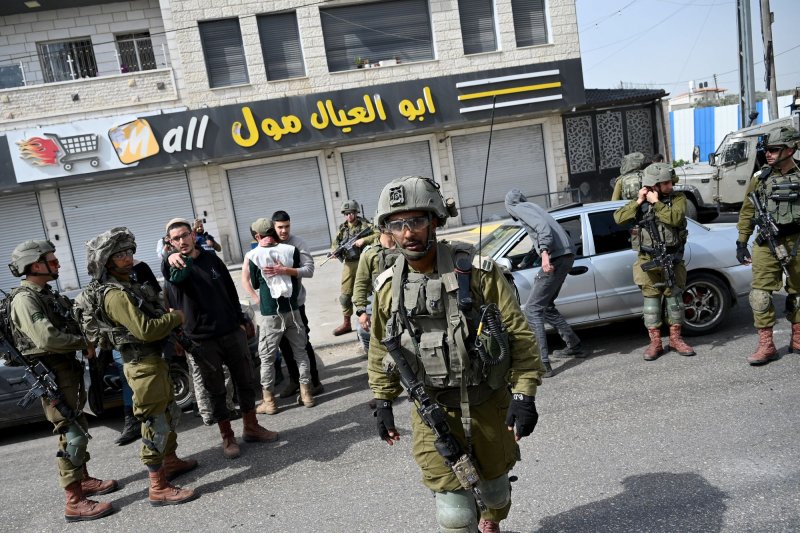 Israeli soldiers protect Jewish settlers in the Palestinian town of Hawara on Monday. Tom Nides, U.S. ambassador to Israel, confirmed that a U.S. citizen has been killed during the outbreak of violence that erupted beginning Sunday night. Photo by Debbie Hill/UPI