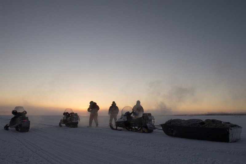 A team including U.S. Marines pause to adjust their gear while traveling via snow machine across the Northwest Arctic Borough in Alaska last year. Photo by Alejandro Pena/U.S. Air Force/UPI
