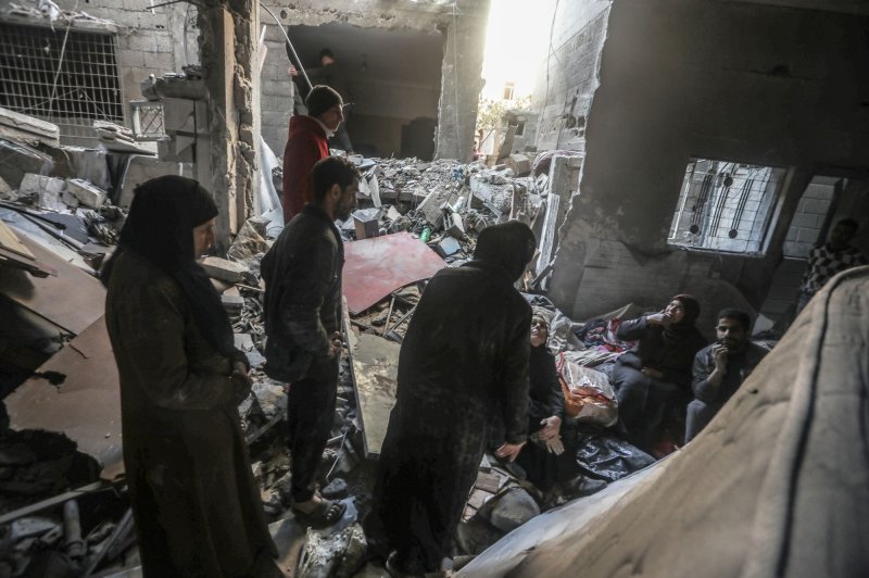 Palestinians inspect a house destroyed in an Israeli bombardment on Rafah in the southern Gaza Strip on Thursday. Some 110 people, including 25 in Rafah, were killed in Israeli airstrikes overnight Saturday, Palestinian health officials said. Photo by Ismael Mohamad/UPI