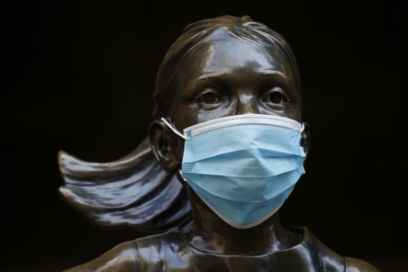 A mask covers the face of the Fearless Girl Statue on Wednesday outside of The New York Stock Exchange on Wall Street in New York City. Photo by John Angelillo/UPI | <a href="/News_Photos/lp/3be8e4e901ecce4e03923ecf66ac88ce/" target="_blank">License Photo</a>