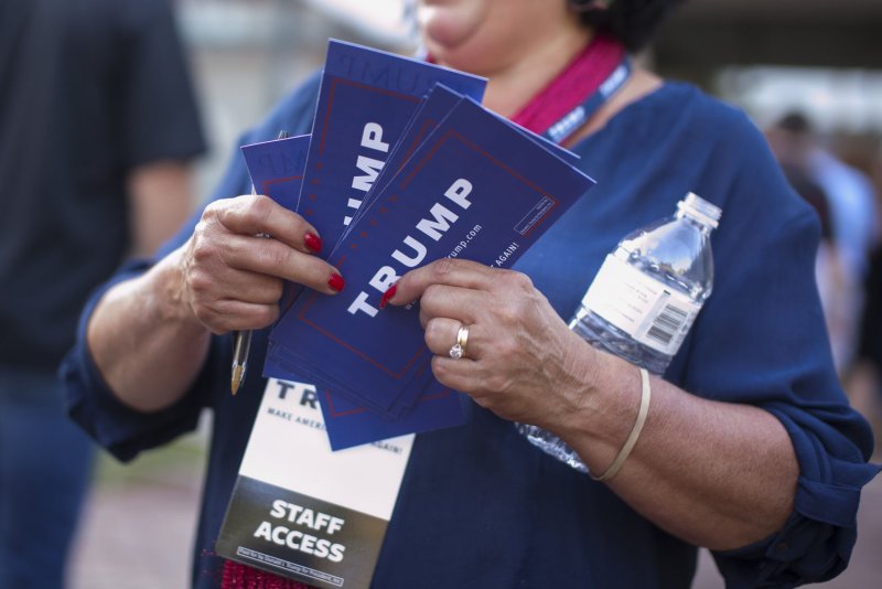 A campaign worker promotes then-Republican presidential candidate Donald Trump at Pinkerton Academy in Derry, N.H., on August 19, 2015. Elliott Broidy, charged Thursday, was a major fundraiser for the Trump campaign four years ago. File Photo by Matthew Healey/UPI