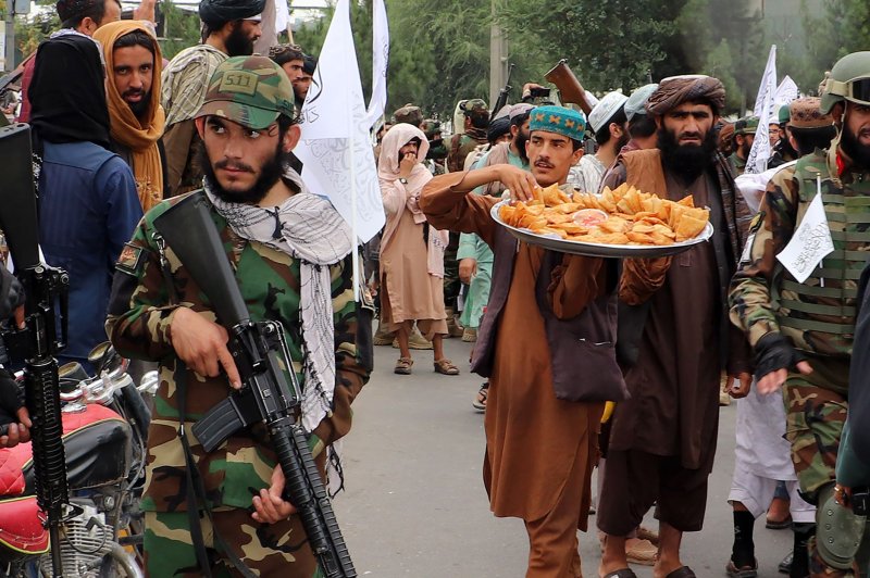 Taliban supporters distribute sweets during a demonstration in support of the first anniversary of the Taliban rule in Kandahar, Afghanistan on Monday. Photo by Shekib Mohammadyl/UPI | <a href="/News_Photos/lp/28d9c099984db920d34f4175c8355b62/" target="_blank">License Photo</a>
