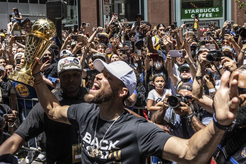 Golden State Warriors guard Stephen Curry takes the NBA Finals MVP trophy out to the fans during a parade up Market Street to honor the team's NBA championship in San Francisco in 2022. File Photo by Terry Schmitt/UPI