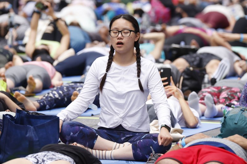 People attend a yoga class at the 20th Anniversary celebration of the Summer Solstice in Times Square: Mind Over Madness Yoga, an annual all-day outdoor yoga event, in New York City on June 21, 2022. File Photo by John Angelillo/UPI