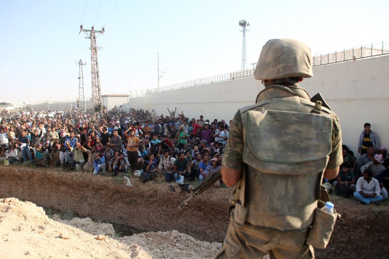 Turkish soldiers guard while hundreds of Syrian refugees fleeing fighting wait at the Syrian side of the border crossing in Akcakale, Sanliurfa province, southeastern Turkey, June 14, 2015. On Wednesday, Turkey launched an offensive in the Syrian city of Jarablus, which is a key Islamic State supply route. File Photo by Ebrahem Khadir/UPI | <a href="/News_Photos/lp/a86657cc4dac0f89ec841c81c26a65f3/" target="_blank">License Photo</a>