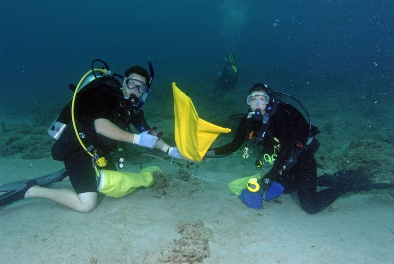SCUBA divers Chris Richard (l) and Terri Coburn (r) attach a lift bag to a heavy piece of trash found along the reef offshore from Pompano Beach, Florida on June 10, 2006 while participating at the Ocean Watch Foundation's annual "Reef Sweep". The Ocean Watch Foundation has sponsored the event for the past eighteen years and is dedicated to the preservation and protection of the coral reef ecosystems in South Florida. Nearly three tons of trash were picked up during the day's event by over 900 local volunteers. .(UPI Photo/Joe Marino)