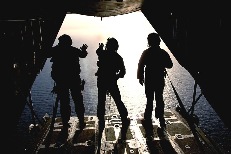 Three U.S. Air Force HC-130 King aircraft loadmasters from the 71st Search and Rescue Squadron watch a smoke grenade from the back ramp of an aircraft during a mission off the coast of Djibouti on June 3, 2008. (UPI Photo/Tech. Sgt. Jeremy T. Lock/USAF)