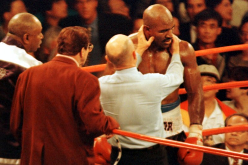 Veteran referee Mills Lane inspects the right ear of defending heavyweight champion Evander Holyfield after challenger Mike Tyson bit it in Round 3 of their title fight on June 28, 1997, at the MGM Grand in Las Vegas. Tyson was disqualified moments later after biting Holyfield's left ear. File Photo by Jim Ruymen/UPI | <a href="/News_Photos/lp/a6ed53d3c373b78a79b6e00eff07b300/" target="_blank">License Photo</a>
