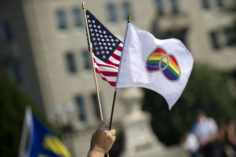 A person holds flags in front of the Supreme Court in Washington, D.C on, June 26, 2013. The Supreme Court ruled DOMA unconstitutional, allowing married same-sex couples to federal benefits, and declining to decide on the California Proposition 8 same-sex marriage case. UPI/Kevin Dietsch