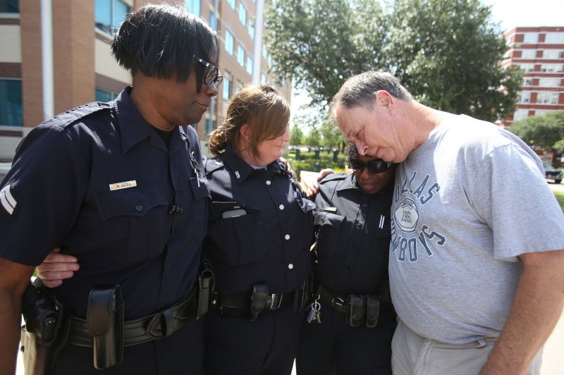 An officer gets emotional while standing outside Dallas Police headquarters in Dallas on July 8. Four police officers and one Dallas Area Rapid Transit officer were killed and several others were injured after a sniper opened fire during a peaceful Black Lives Matter march late on July 7, 2016. File Photo by Chris McGathey/UPI