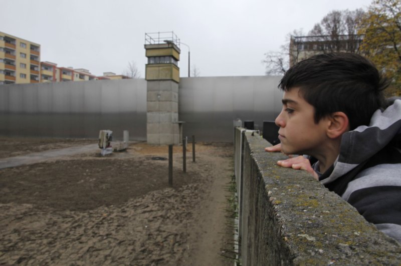 A boy looks over an original segment of the Berlin Wall at the Bernauer Strasse memorial on the 20th anniversary of the fall of the Wall on November 9, 2009 in Berlin. On November 9, 1989, East Germany announced free passage for its citizens through border checkpoints, rendering the Berlin Wall virtually irrelevant. File Photo by David Silpa/UPI