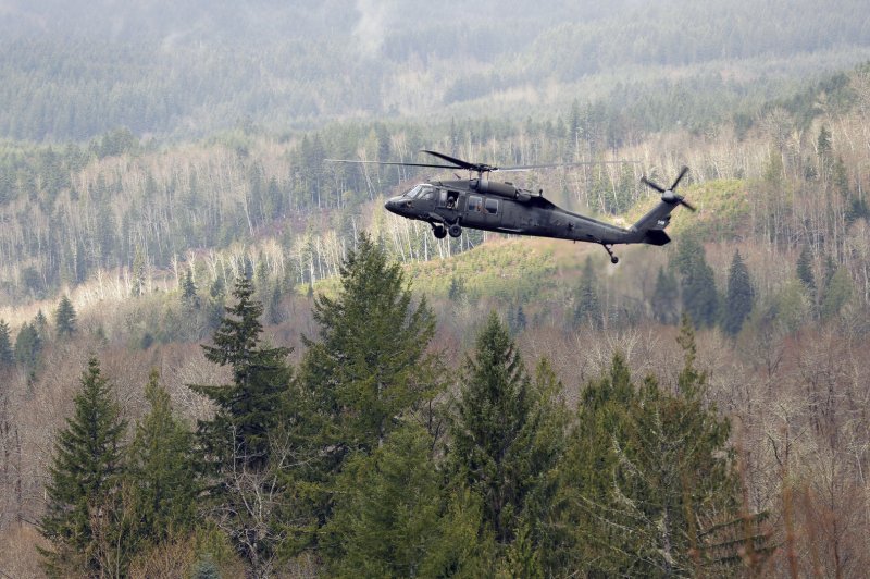 A military search and rescue helicopter hovers over the debris field on on March 27, 2014 in Oso, Washington. Over 200 search and rescue personnel continue to search for survivors or bodies in the aftermath of Saturday's mudslide that buried the town of Oso, about 12 miles west of Darrington. As of Thursday, there are 25 dead and 90 missing. UPI/Ted Warren/Pool