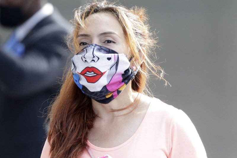 A masked women walks on the grounds of Hudson Yards in New York City on Saturday. Photo by John Angelillo/UPI