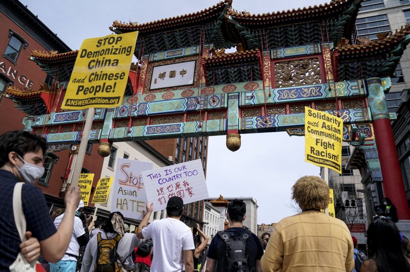 People gather and hold signs during an ANSWER Coalition Anti-Asian Violence rally in the Chinatown neighborhood of Washington, D.C., on Friday. Photo by Leigh Vogel/UPI