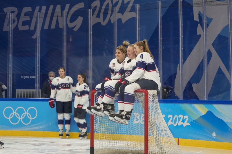 Team USA women's hockey members Brianna Decker (L), Grace Zumwinkle (C) and Caroline Harvey sit on top of the goal as they pose for a picture before a practice session Tuesday at the Cadillac Center in Beijing Photo by Paul Hanna/UPI