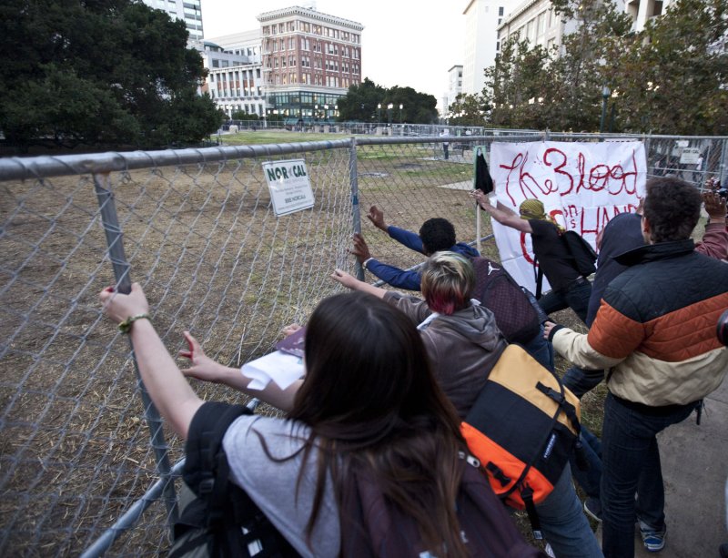 Occupy Oakland protesters push on a chain link fence surrounding Frank H. Ogawa Plaza in Oakland, California on October 26, 2011. The city erected the fence to keep demonstrators from camping in the plaza after clearing out their encampment. UPI/Terry Schmitt
