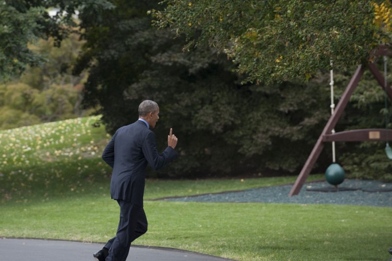 U.S. President Barack Obama sprints back to the Oval Office after forgetting his smartphone prior to boarding Marine One for a trip to Chicago on Friday. The president emerged about 30 seconds later, flashing a smile with phone in hand. Photo by Rod Lamkey/Pool/UPI