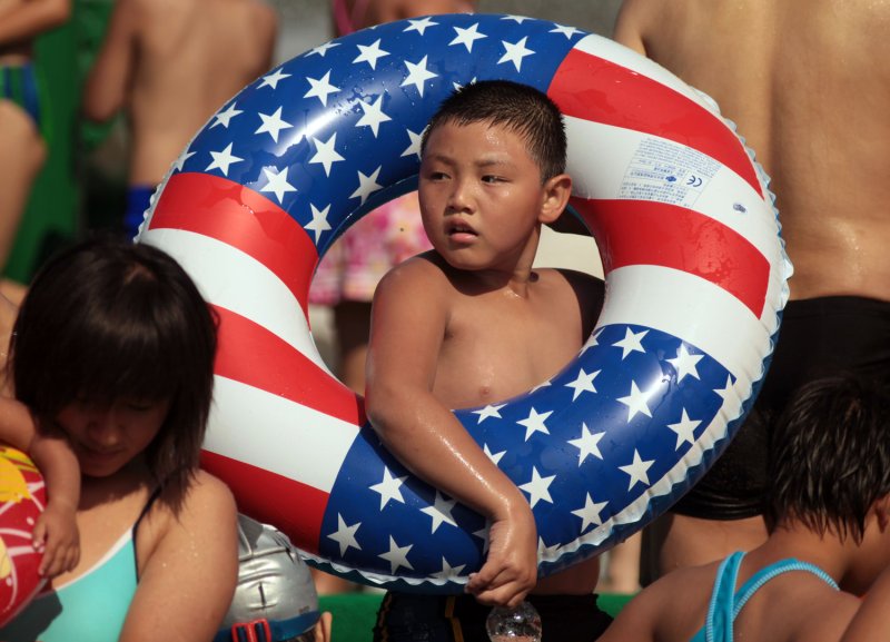 Chinese kids, or 'beach-goers', visit a local park's "Beach Carnival", featuring real sand and a massive outdoor swimming pool in Beijing. UPI/Stephen Shaver | <a href="/News_Photos/lp/7da1a915d361f859482838f31dafc14c/" target="_blank">License Photo</a>