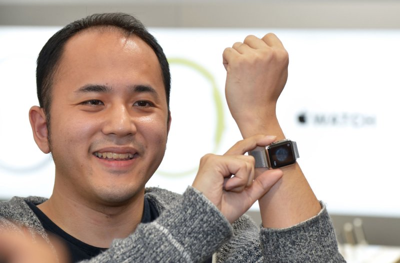 A Tokyo customer of Softbank Mobile Co. in Tokyo, Japan, shows off his purchase of a new Apple watch. On Monday, Softbank announced it is aquiring the British company ARM Holdings, whose semiconductors are used in Apple watches. Photo by Keizo Mori/UPI