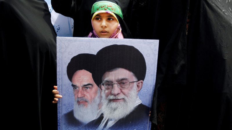 An Iranian girl holds a picture of Iran's late leader Ayatollah Khomeini (L) and Iran's current Supreme Leader Ayatollah Khamenei (R) during a rally in support of Iran's strict Islamic dress codes after Friday prayers in Tehran, Iran on July 8, 2011. UPI/Maryam Rahmanian