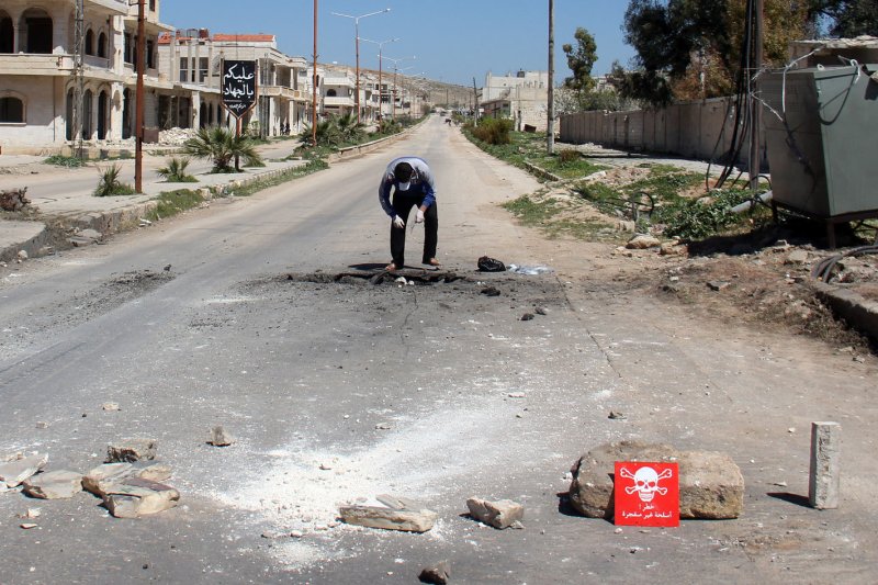 A Syrian man collects samples from the site of a suspected gas attack in Khan Sheikhun, Syria, on April 5. The attack killed at least 100 civilians, including several children. File Photo by Omar Haj Kadour/UPI