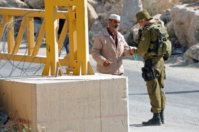 An Israeli soldier checks a Palestinian at a security checkpoint in Hebron on June 17, 2014. The U.S. government is speaking out about Israel's plans to expand Jewish settlement in Hebron, the second largest city in the Palestinian territories after Gaza. File photo by Debbie Hill/UPI
