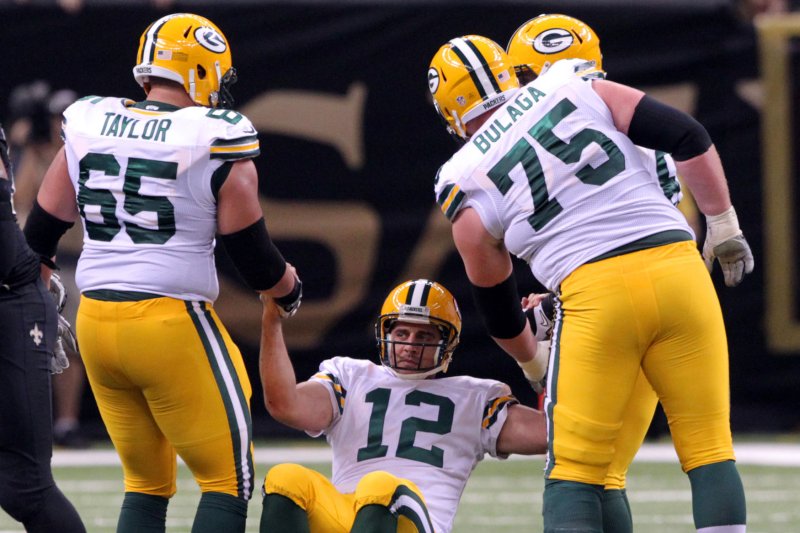 Green Bay Packers quarterback Aaron Rodgers (12) is helped up by teammates Lane Taylor (65) and tackle Bryan Bulaga (75) during the between the Packers and the New Orleans Saints at the Mercedes-Benz Superdome in New Orleans October 26, 2014. File photo by A.J. Sisco/UPI