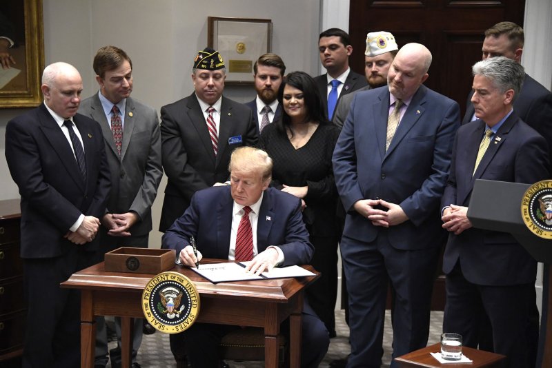 President Donald Trump signs an Executive Order concerning the suicides of military veterans, at the White House, on Tuesday. Witnessing are Arizona Coalition for Military Families Thomas Winkel, second right, and Senate Sgt. at Arms Frank Larkin (R), whose US Navy SEAL son, Ryan, killed himself. Photo by Mike Theiler/UPI