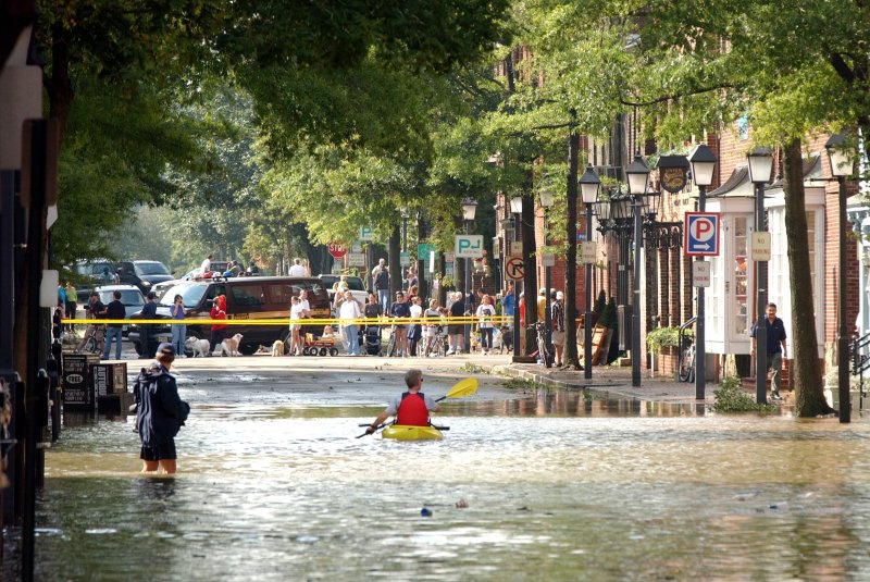Residents brave the floodwaters in the streets of Alexandria, Va., on September 19, 2003, after Hurricane Isabel slammed the East Coast. The storm made landfall September 18. File Photo by Roger L. Wollenberg/UPI