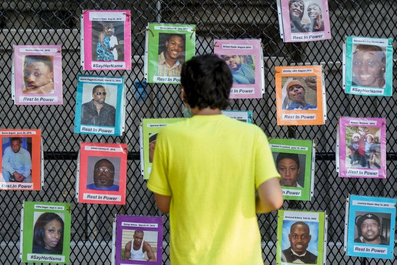 A young man looks at photographs of Black Americans who have died by violence in the United States, on a fence outside the White House in Washington, D.C., on July 4. File Photo by Leigh Vogel/UPI | <a href="/News_Photos/lp/0a1c6b3f64aa3af0f66b69c492ca456d/" target="_blank">License Photo</a>