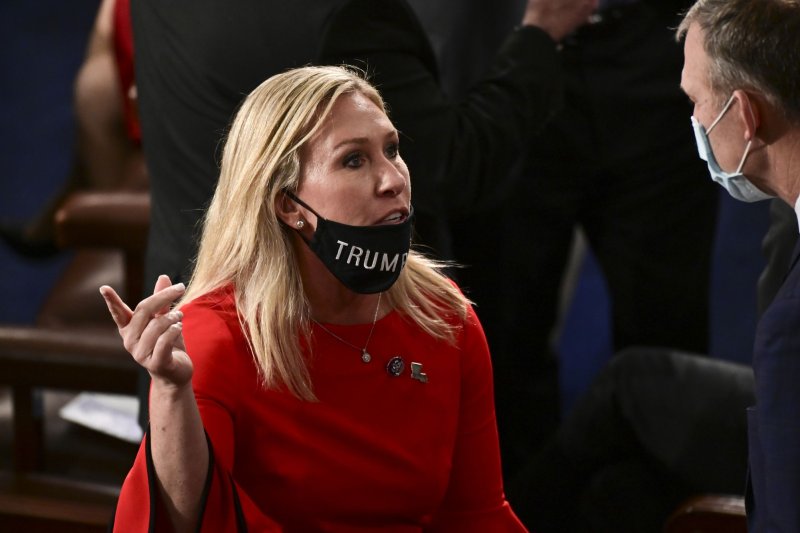 U.S. Rep. Marjorie Taylor Greene, R-Ga., speaks to a&nbsp; colleague with her "Trump Won" face covering pulled down below her mouth on the House floor on January 3. Twitter suspended Greene's account temporarily Sunday. Photo by Erin Scott/UPI