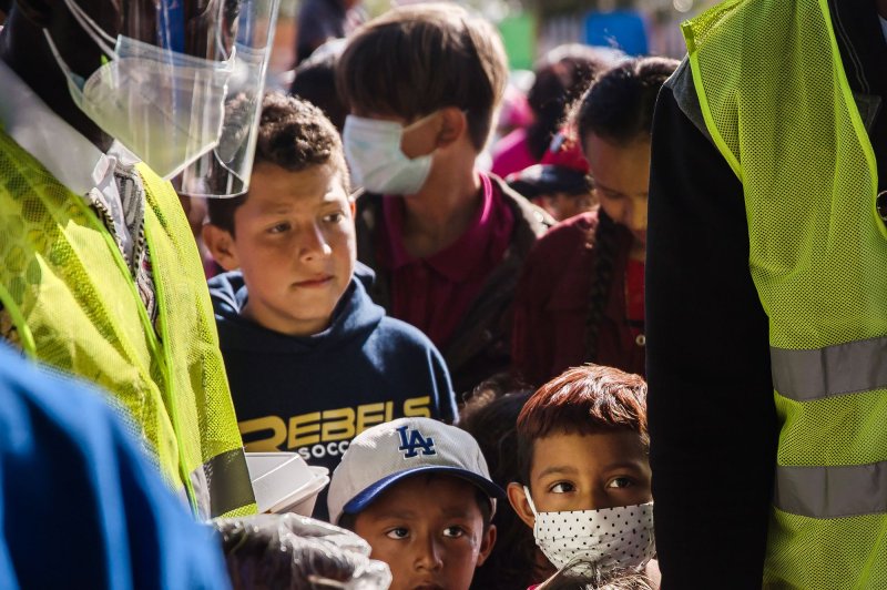 Children wait in line for food near El Chaparral plaza in Tijuana, Mexico, in March 2021. File Photo by Ariana Drehsler/UPI