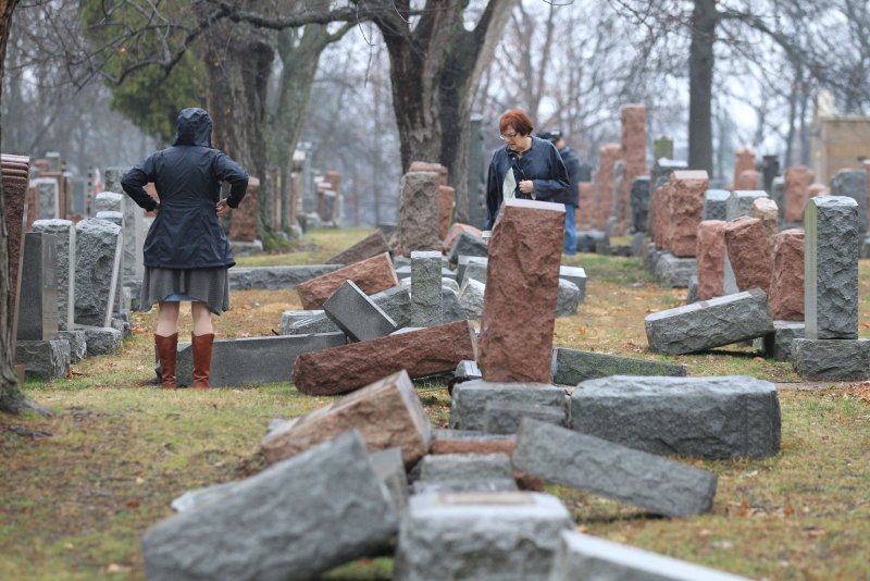 Visitors to the Chesed Shel Emeth Cemetery in University City on February 21 check the names on headstones damaged after vandals toppled nearly 200 stones in the Jewish cemetery. File Photo by Bill Greenblatt/UPI