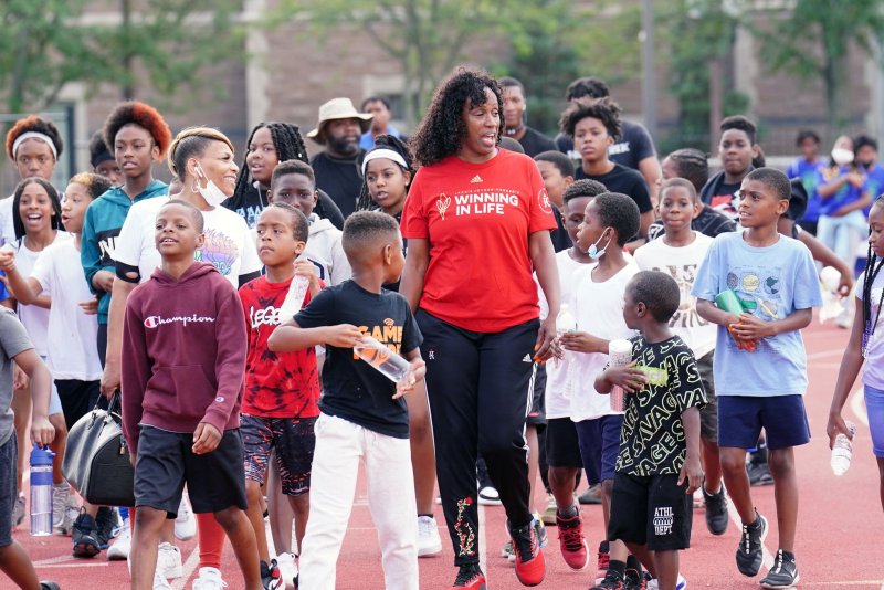 Six-time Olympic medalist Jackie Joyner-Kersee walks with children on the campus of Washington University in St. Louis on June 22 in observance of World Olympic Day. A global study of children and adolescents indicates their daily physical activity decreased by roughly 20% during the height of the COVID-19 pandemic. Photo by Bill Greenblatt/UPI