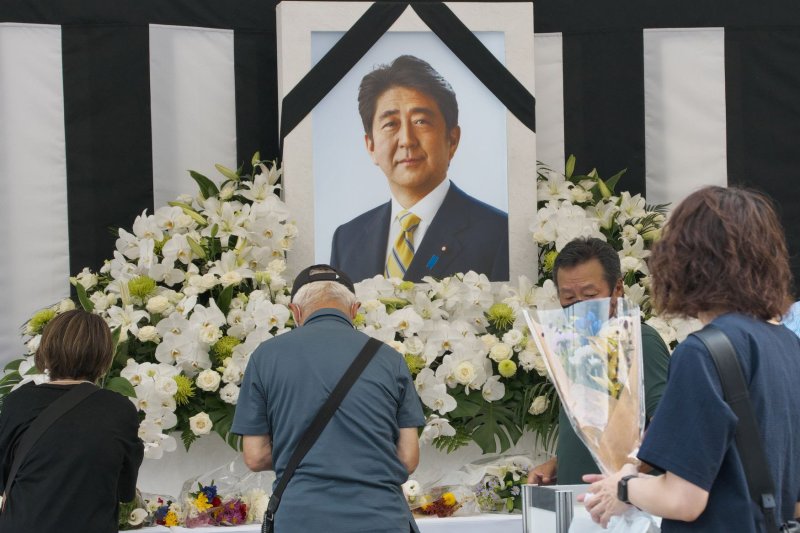 People offer flowers at the memorial outside Nippon Budokan during the state funeral of Japan's former Prime Minister Shinzo Abe in Tokyo on Tuesday. Photo by Keizo Mori/UPI | <a href="/News_Photos/lp/a0f018492e40d9bbb85e74ed47b6b1c6/" target="_blank">License Photo</a>