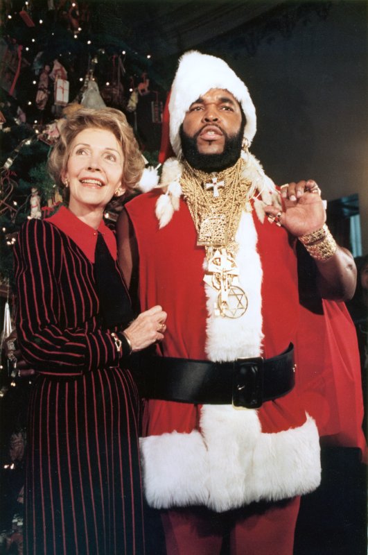 "Mr. T", star of the TV show the "A-Team" poses as Santa Claus December 12, 1983 to help First Lady Nancy Reagan unveil the White House Christmas decorations. (UPI PHOTO/Larry Rubenstein/FILES) | <a href="/News_Photos/lp/dc0c8e56241bbffdd70d7429e470cb20/" target="_blank">License Photo</a>