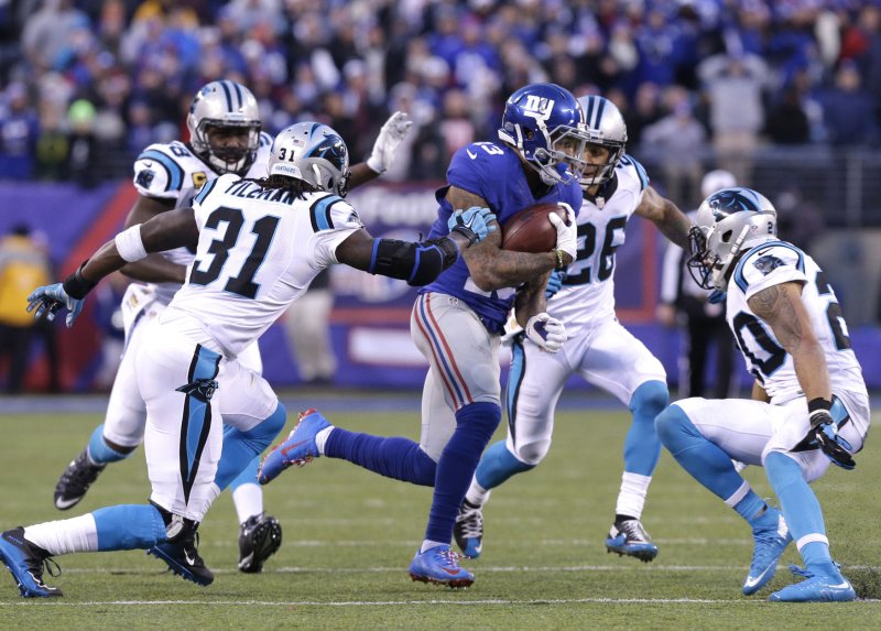 New York Giants Odell Beckham Jr. is surrounded by Carolina Panthers defenders when he makes a 40 yard reception in the 4th quarter at MetLife Stadium in East Rutherford, New Jersey on December 20, 2015. The Panthers defeated the Giants 38-35 and remain undefeated at 14-0. Photo by John Angelillo/UPI