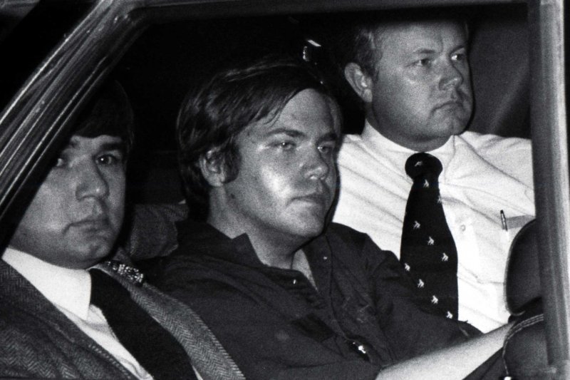 John Hinckley Jr. is flanked by federal agents as he is driven away from court April 10, 1981. The son of a former Colorado oilman, Hinckley was convicted in a 1982 trial that included evidence he shot Reagan in an effort to impress Jodie Foster, an actress he had never met. File Photo UPI