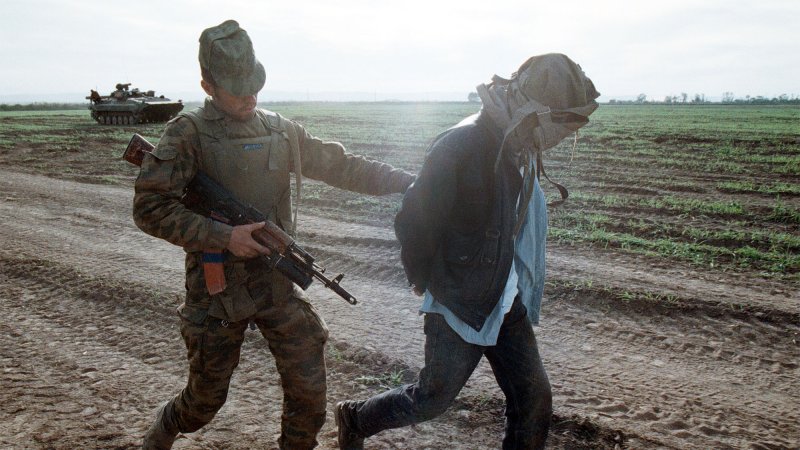 A Russian soldier leads away a captive during fighting between the Russian army and Islamic militants near Grozny in the break-away republic of Chechnya, October 18. Militants staged a drawn-out guerilla war against the Russians in a bid for independence. Maxim Marmur/UPI