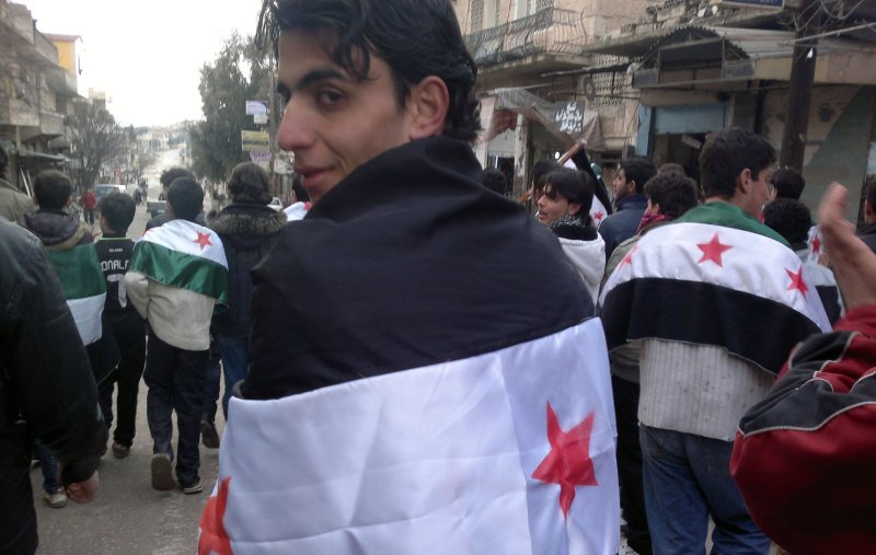 Syrian demonstrators wear Syrian independence flags during a protest against Syria's President Bashar al-Assad in Kafranbel, Syria, February 19, 2012. UPI